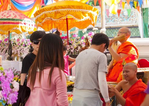 BANGKOK-APRIL 16:Unidentified monk pouring a holy water to people for a good luck in Songkran festival tradition of thailand. 
April 16,2014 in Bangkok ,Thailand