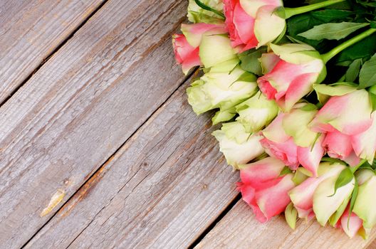 Bunch of Beauty Pink And White Roses in Corner on Rustic Wooden background