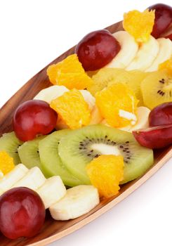 Fruit Salad with Red Grape, Green and Golden Kiwi, Bananas and Oranges on Wooden Plate isolated on White background