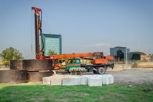 construction site with heavy machinery equipmen and crane cement blocks in city center