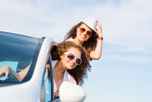 young attractive woman in sunglasses got out of the car window and laugh