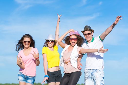 Group of young people having fun on a blue summer sky