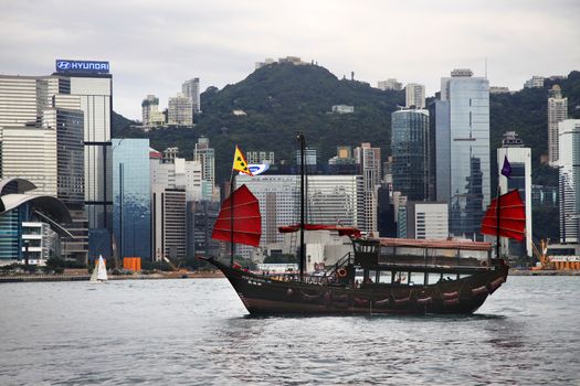 HONG KONG - APRIL 26: view of Hong Kong's Vicotria harbor with one chinese boat through the river April 26, 2014, Hong Kong