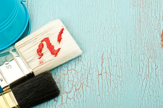 Paint brushes on a shabby blue wooden background
