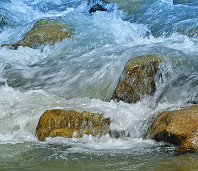 background stone with water circulating within wild river