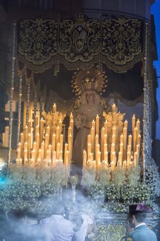 Linares, Jaen province, SPAIN - March 17, 2014: Nuestra Señora del Rosario passing by the church of San Francisco with the candeleria illuminated carried by bearers, taken in Linares, Jaen province, Andalusia, Spain
