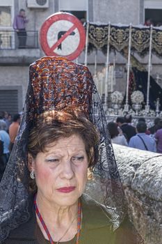 Linares, jaen province, SPAIN - March 16, 2014:  Older woman dressed in mantle during a Holy week procession, behind the Virgen de los Dolores of the brotherhood of Jesus del Rescate, taken in Linares, Jaen province, Andalucia, Spain