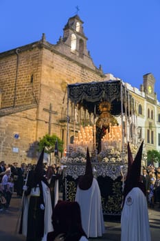 Linares, Jaen province, SPAIN - March 17, 2014: Nuestra Señora de los Dolores passing by the church of San Francisco with the candeleria illuminated carried by bearers, taken in Linares, Jaen province, Andalusia, Spain