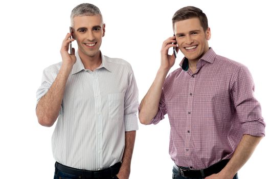 Two handsome men communicating via cellphone