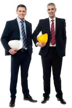 Young engineers with helmets against white background