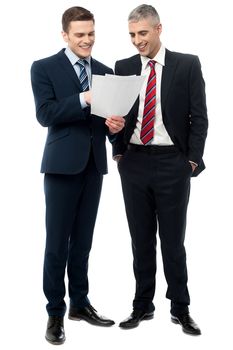 Smiling business executives checking documents