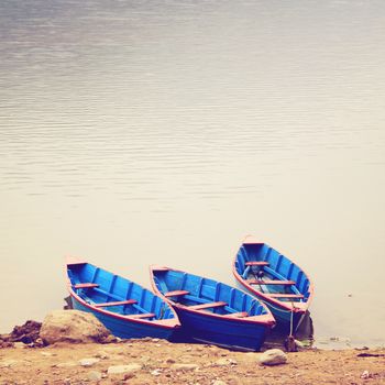 Three boats on the lake with retro filter effect