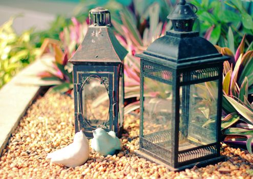 Ceramic birds and vintage lamp for decorated garden with retro filter effect