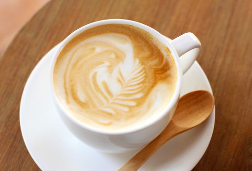 Cup of latte or cappuccino coffee with wooden spoon