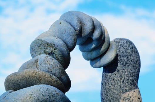 Arc of gray pebbles in the balance on the seacoast