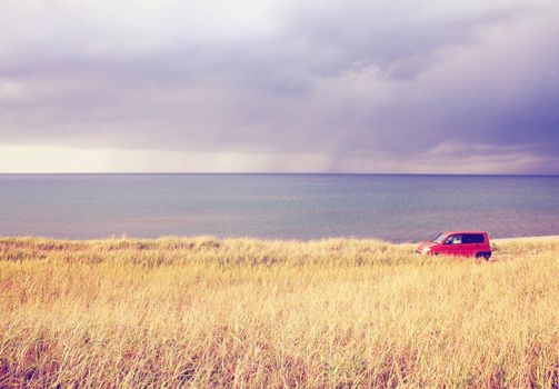 Red car parking in the field with retro filter effect 