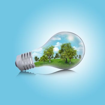 Trees, grass and sky in the light bulb. Concept of safe electricity