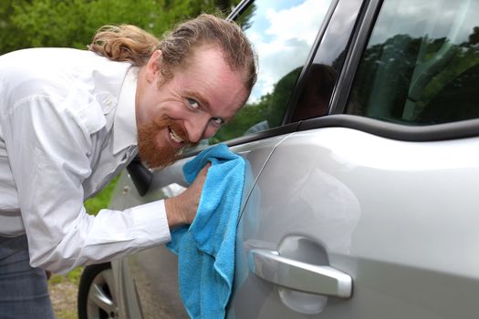 Portrait of funny man washing car with a cloth