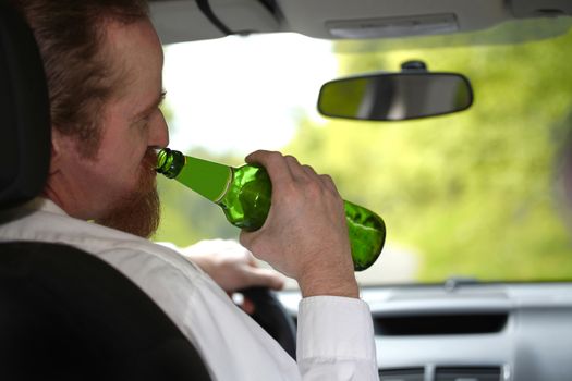 Drunk man in car with a bottle beer