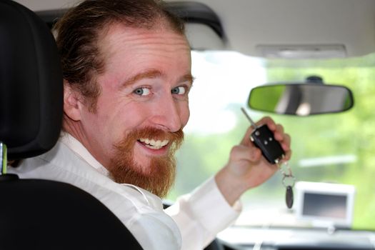driver smiling sitting in car and showing new car keys 