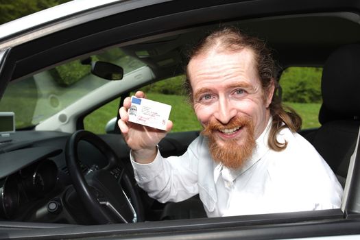 driver smiling sitting in car and showing drivers license