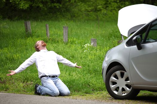 Driver furious a broken car by the road  