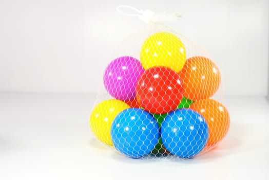 colourful balloon ball in net sac on white scene