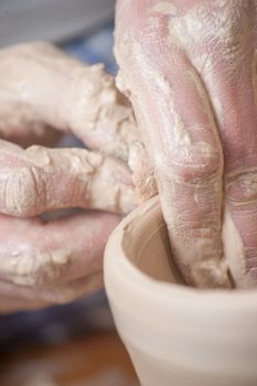 Hands of a potter, creating an earthen jar on the circle