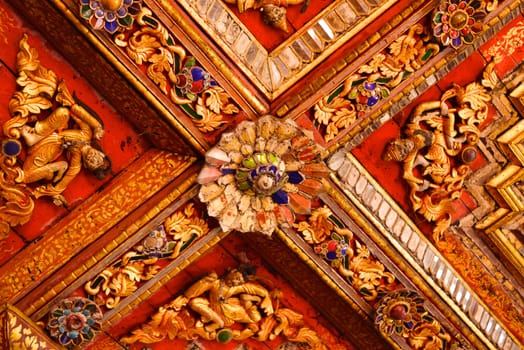 the detail of ancient thai decorated pattern that include handcraft wood carving work,gold painting and decorated with gold plate,mirror and precious stone,Lampang temple,Thailand