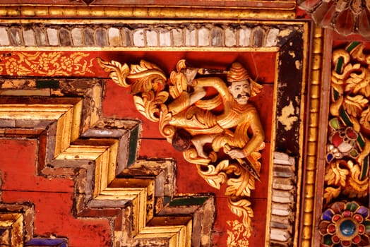 the detail of ancient thai decorated pattern that include handcraft wood carving work,gold painting and decorated with gold plate,mirror and precious stone,Lampang temple,Thailand