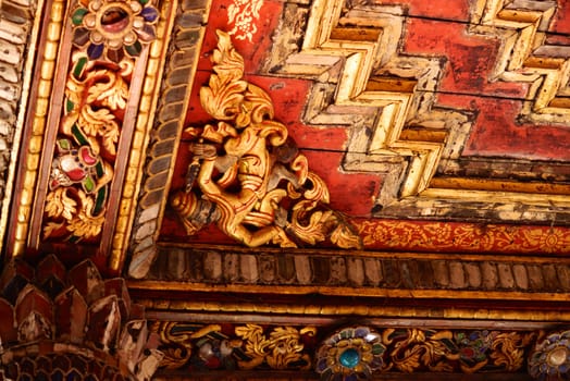 the detail of ancient thai decorated pattern that include handcraft wood carving work,gold painting and decorated with gold plate,mirror and precious stone,Lampang temple,Thailand