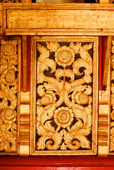 the detail of ancient thai decorated pattern that include handcraft wood carving work,gold painting and decorated with gold plate,mirror and precious stone,Lampang temple,Thailand