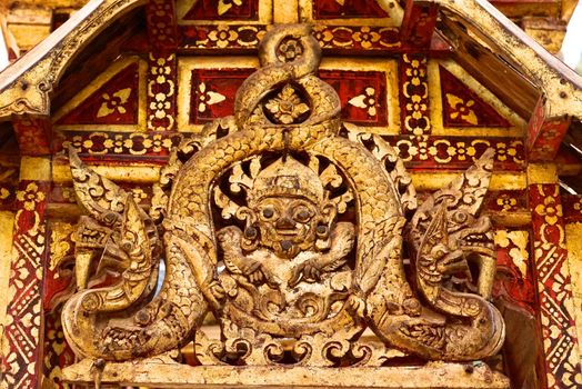 the detail of ancient thai decorated pattern that include handcraft wood carving work,gold painting and decorated with gold plate,mirror and precious stone,Lampang temple,Thailand
