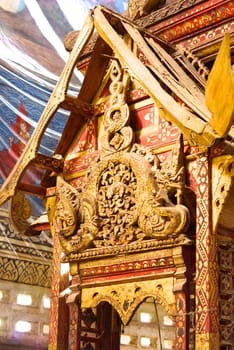 the detail of ancient thai decorated pattern that include handcraft wood carving work,gold painting and decorated with gold plate,mirror and precious stone,Lampang temple,Thailand
