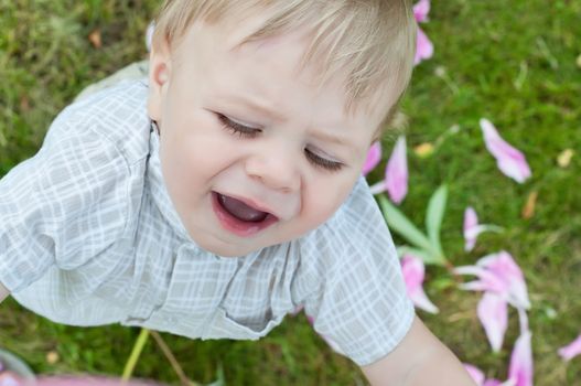 Outdoor shoot of cute unhappy baby boy