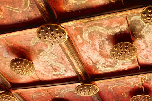 the detail of ancient thai decorated pattern that include handcraft wood carving work,gold painting and decorated with gold plate,mirror and precious stone,Lampang temple,Thailand