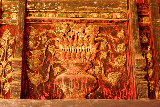 the detail of ancient thai decorated pattern that include handcraft wood carving work,gold painting and decorated with gold plate,mirror and precious stone,Lampang temple,Thailand