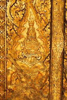 the detail of ancient thai decorated pattern that include handcraft wood carving work,gold painting and decorated with gold plate,mirror and precious stone,Lampang temple,Thailand