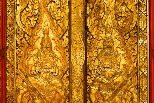 the detail of ancient thai decorated pattern that include handcraft wood carving work,gold painting and decorated with gold plate,mirror and precious stone,Lampang temple,Thailand