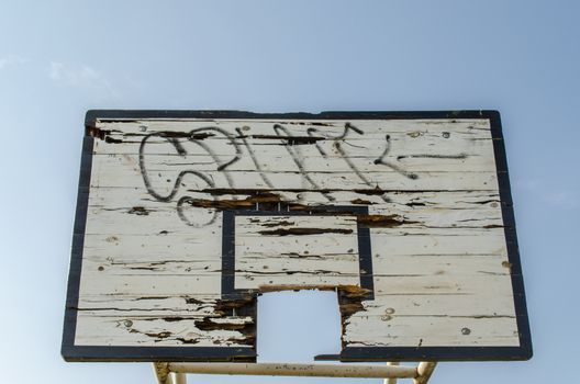 old wooden broken smeared basketball board on blue sky background