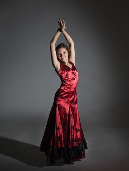 Young woman dancing flamenco, studio shot, gray background