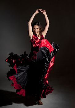 Young woman dancing flamenco, studio shot, gray background