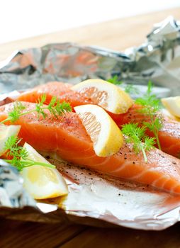 Fresh salmon fillets with lemon wedges and dill