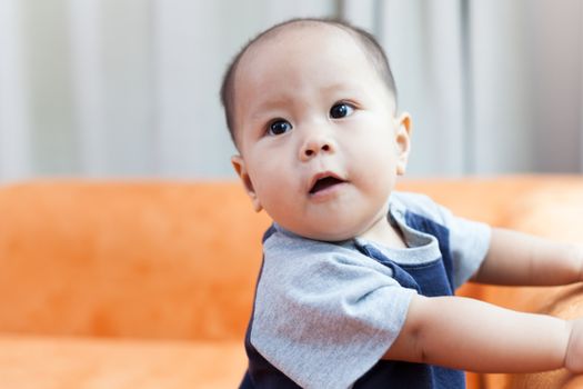 Baby boy.child Asian., And played on the orange sofa.