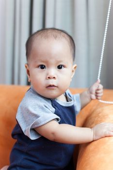 Baby boy.child Asian., And played on the orange sofa.