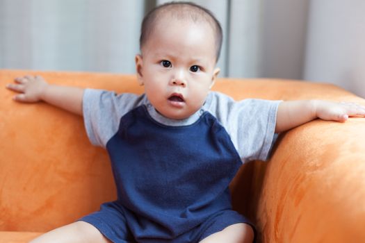 Baby boy.child Asian., And played on the orange sofa.