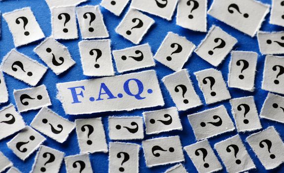 questions faq on cut paper on blue background close up