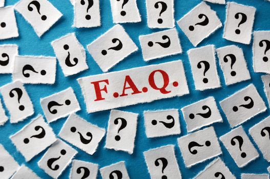 questions faq on cut paper on blue background close up