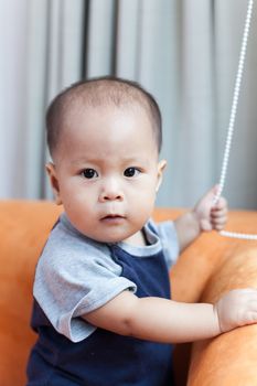 Baby boy.child Asian., And played on the orange sofa.