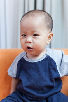 Baby boy.child Asian., And played on the orange sofa.